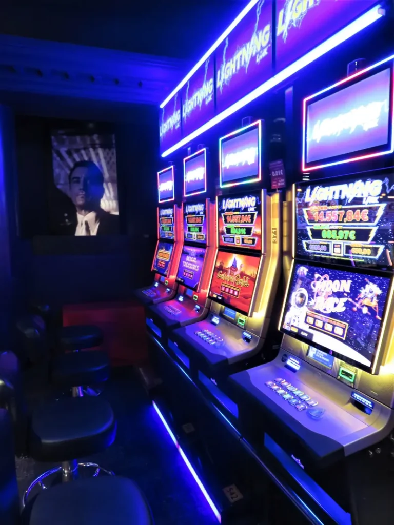 Slot machines glowing under blue lights at Casino JOA Les Pins des Sables d'Olonne