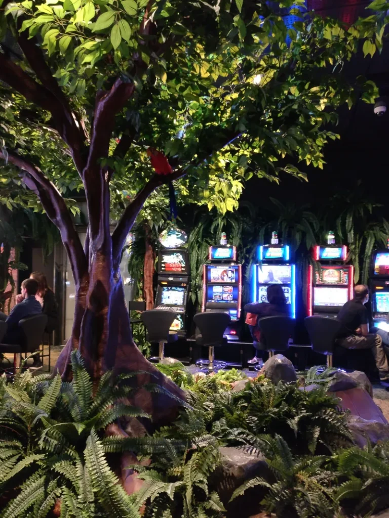 Slot machines beside indoor greenery at Casino de Bourbon-l'Archambault