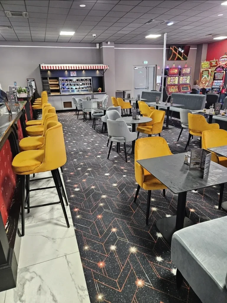Cafe tables and yellow chairs inside Casino de Fort-Mahon-Plage